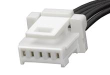 Biely, obdĺžnikový konektor so štyrmi otvormi a čiernymi káblami, kompatibilný s elektrickými zariadeniami pre pripojenie.
