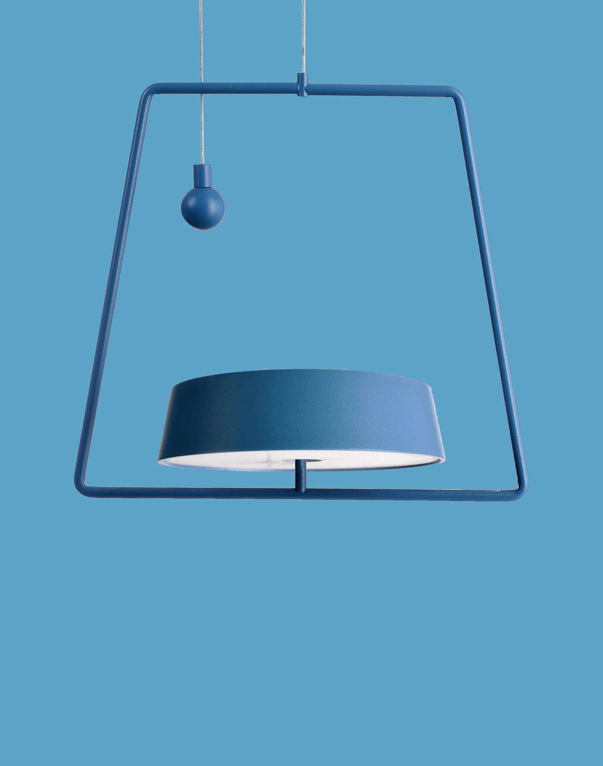 Moderná, modrá závesná lampa s geometrickým dizajnom, vznášajúca sa pred modrým pozadím.