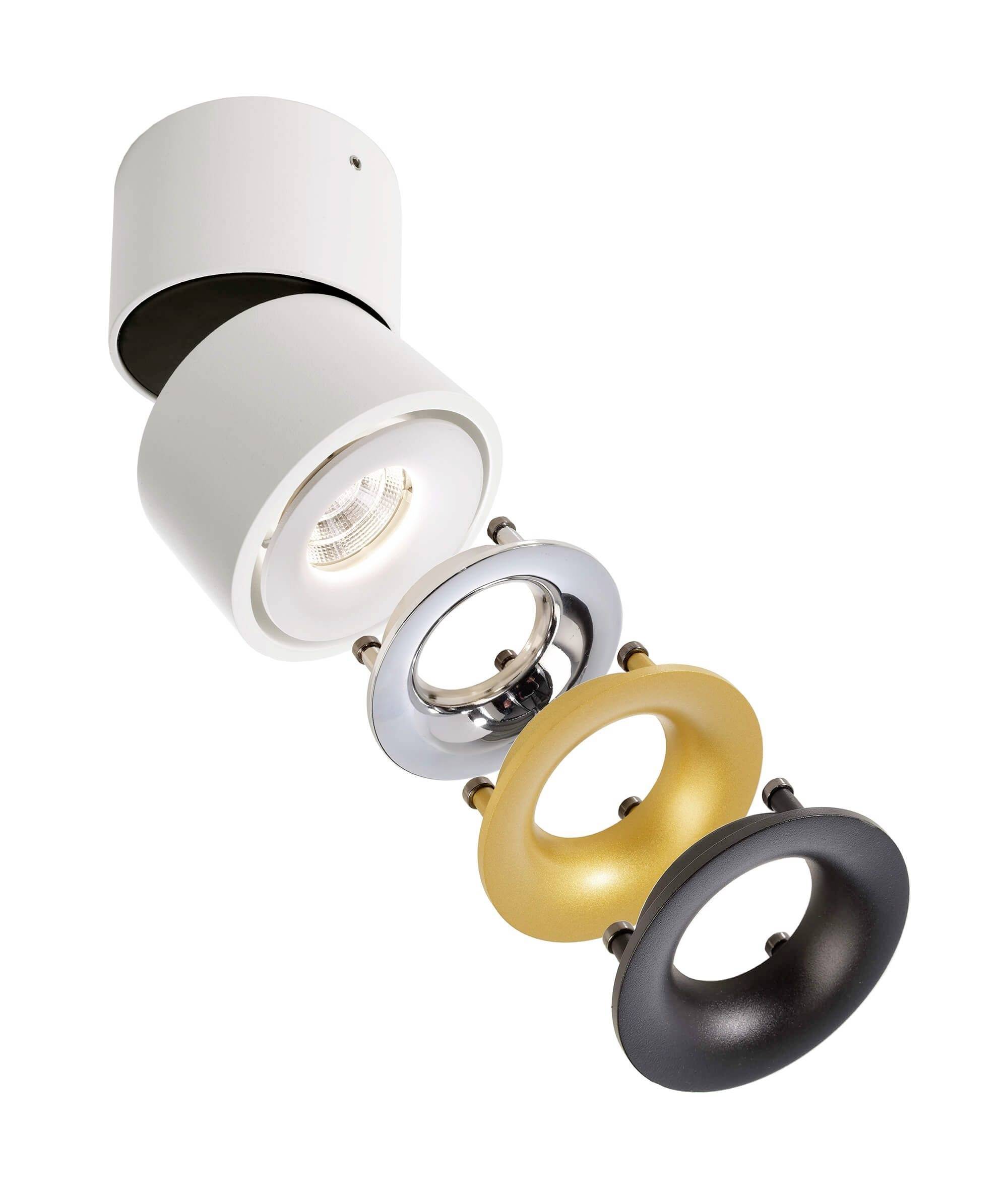 Biela stropná lampa so štyrmi vymeniteľnými krúžkami v striebornej, zlatej a čiernej farbe, ktoré možno umiestniť pod svetlo.