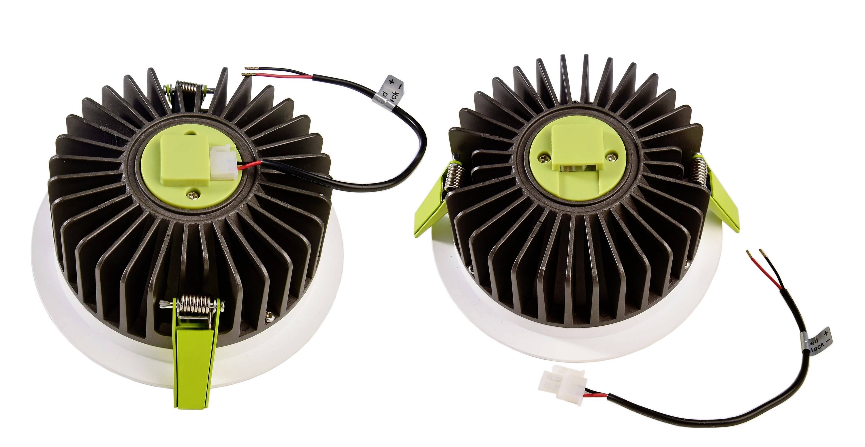 Dva okrúhle LED zapustené reflektory s chladiacimi rebrami a káblami na bielom pozadí.