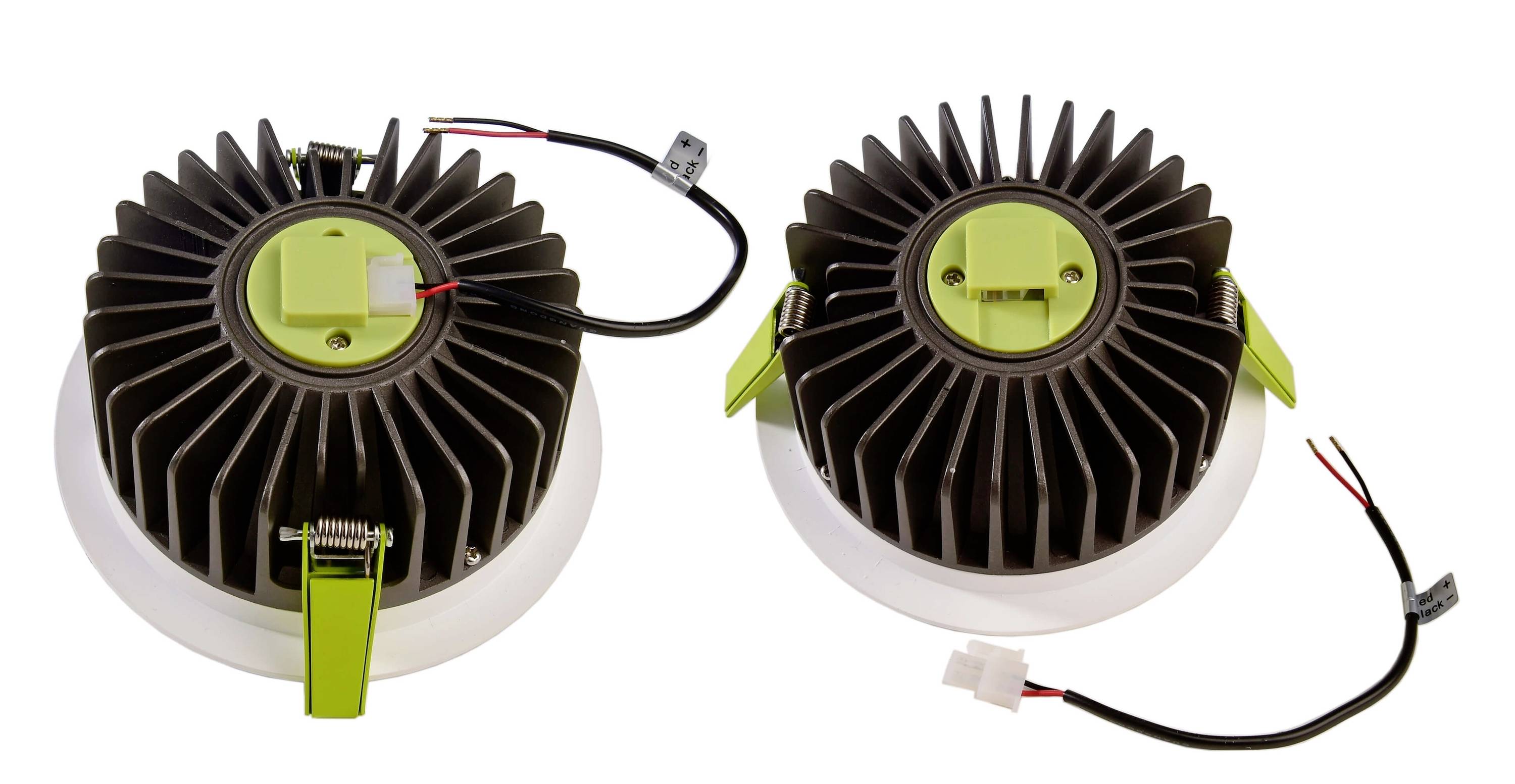 Dva okrúhle LED diely lámp s chladičmi v čiernej a zelenej farbe na bielom pozadí, káble sú viditeľne pripojené.