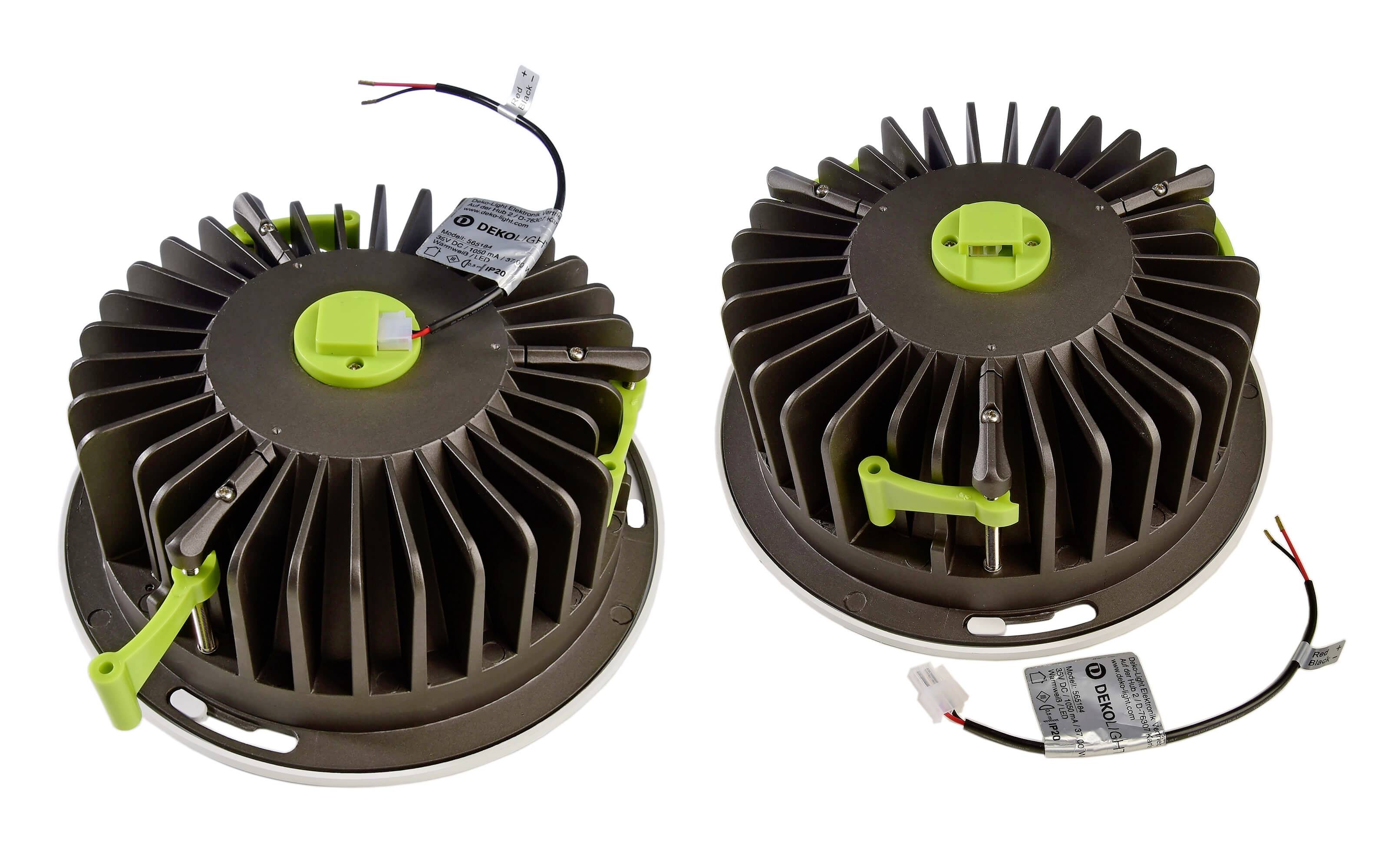 Dva okrúhle, kovové chladiče so zelenými plastovými prvkami a káblami, ktoré sa používajú na odvod tepla z elektronických zariadení.