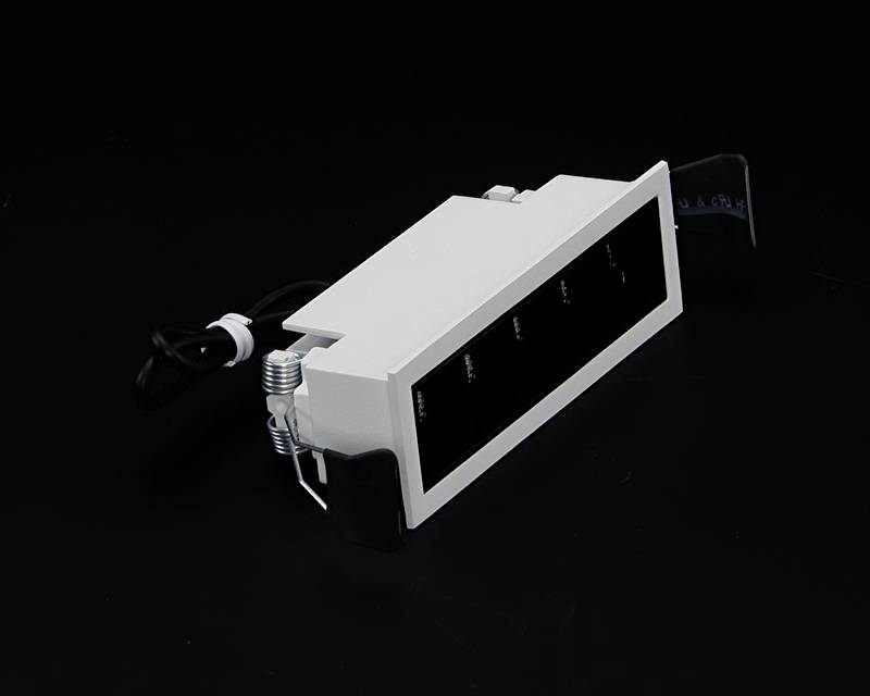 Obdĺžnikový čierny rozvádzač s káblovým pripojením leží na tmavom pozadí.