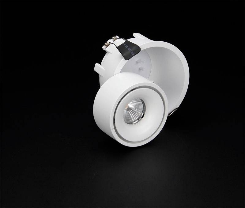 Zapustené svietidlo s okrúhlym bielym krytom na čiernom pozadí. Osvetľovací prvok vpredu viditeľný. Moderný dizajn.