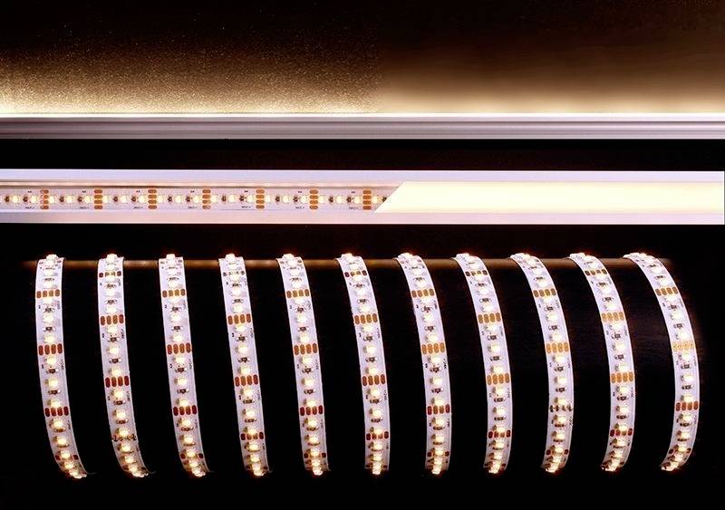 Rôzne LED pásy svietia teplými farbami, usporiadané v rovnobežných radoch a odrážajú svetlo na tmavom povrchu.