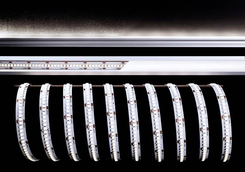 Rolky flexibilných LED svetelných pásov umiestnené na čiernom pozadí.