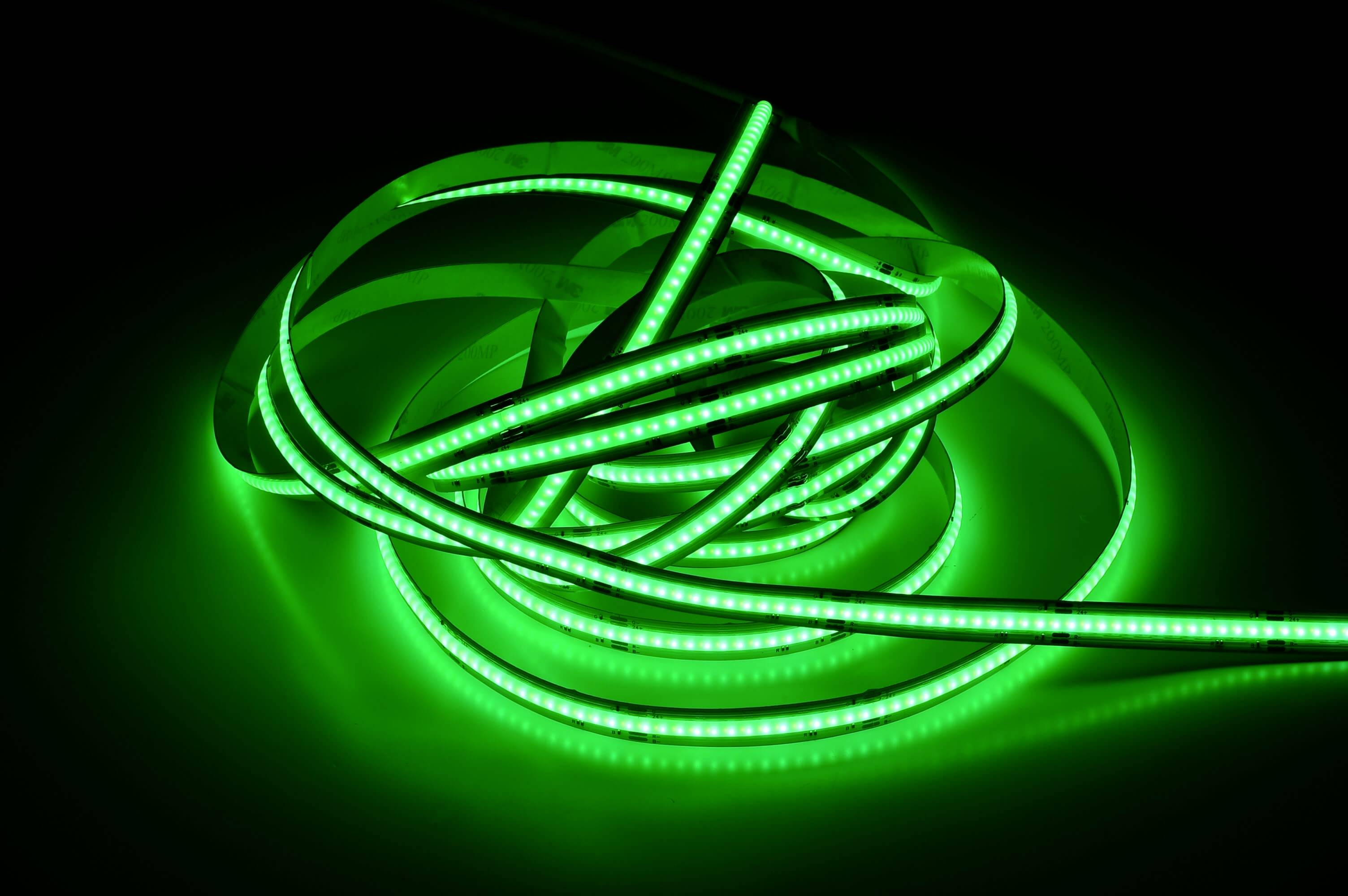 Svetelný, zeleno svietiaci LED pás stočený na čiernom pozadí.