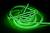 Svetelný, zeleno svietiaci LED pás stočený na čiernom pozadí.