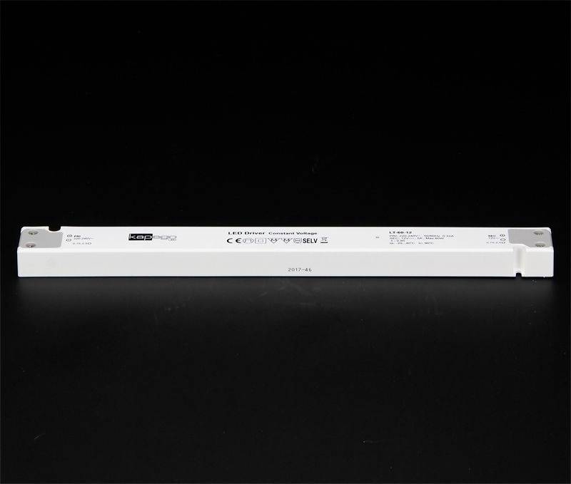 LED budič v podlhovastom bielom tvare leží na čiernom pozadí. Text a technické údaje sú vytlačené na hornej strane.