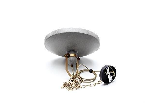 Okrúhly sivý popolník so zlatou reťazou a čiernym príveskom leží na bielom povrchu.