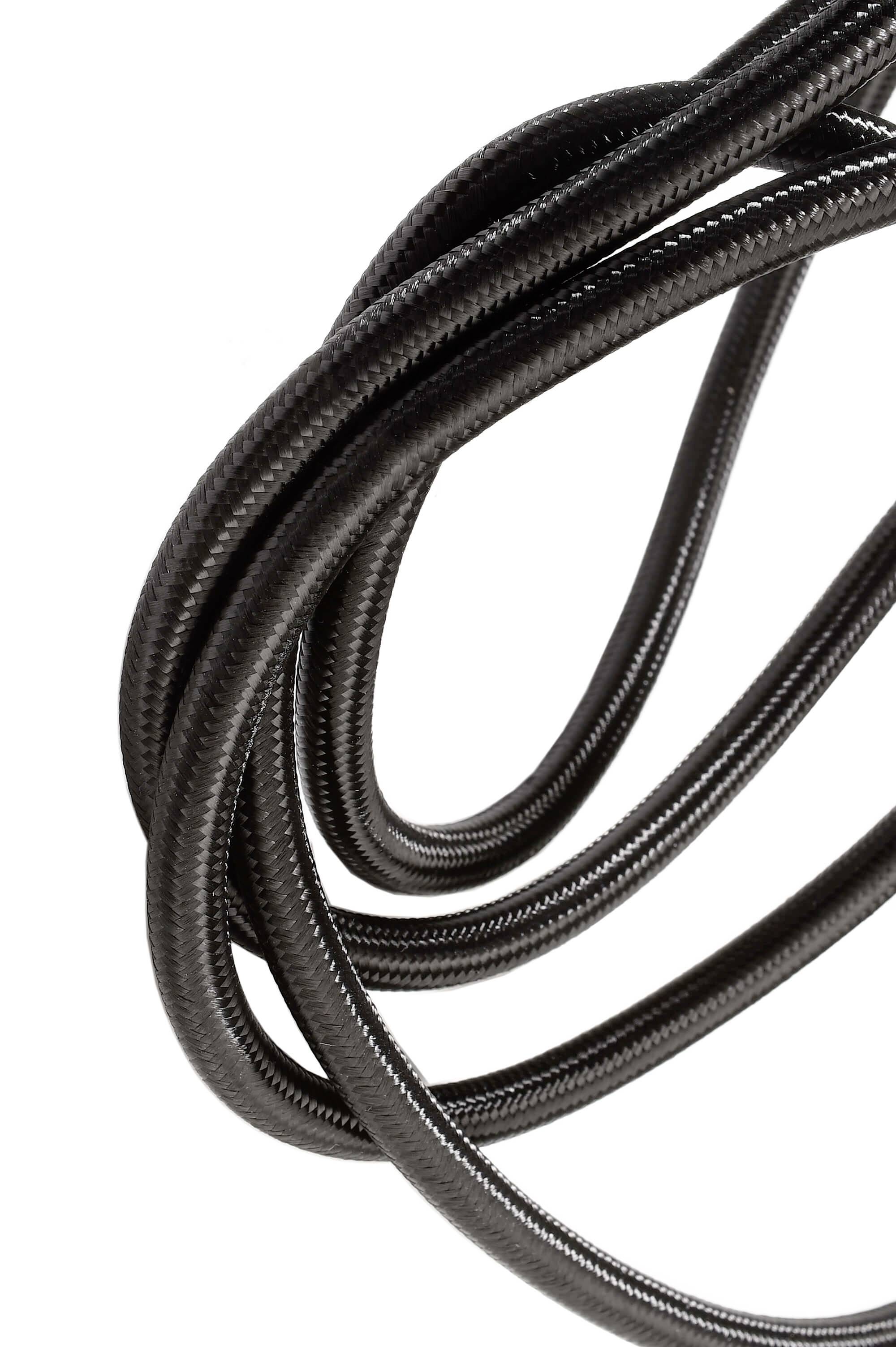 Úzko stočený čierny kábel na bielom pozadí. Pôsobí flexibilne a odolne.