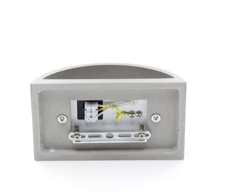 'Zadný pohľad na obdĺžnikovú sivú nástennú lampu so viditeľným pripojením a skrutkami. Vhodná na vonkajšiu montáž.'