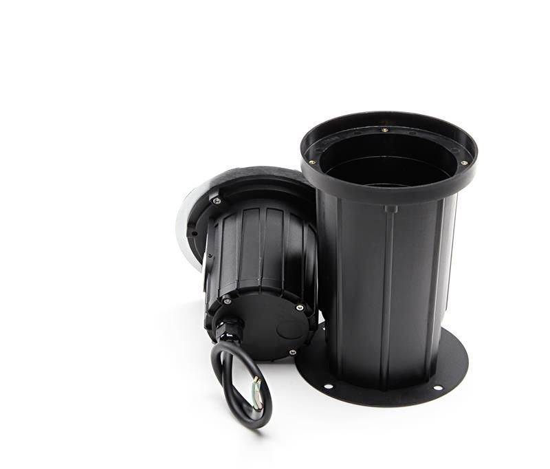 Čierny valcový box zapustený do zeme, vedľa neho zodpovedajúci svetelný prvok s káblom, pripravený na inštaláciu.