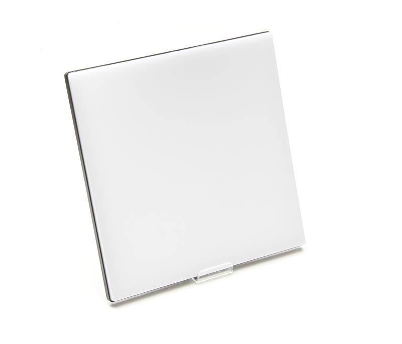 Biely štvorcový fotorámček stojí šikmo na malom stojane na bielom pozadí.