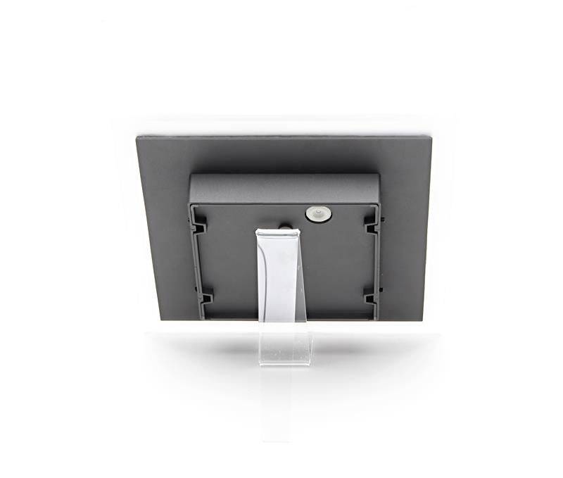 Digitálny fotorámček stojí na priehľadnom stojane, zachytený pohľadom zozadu. Rámček je čierny a obdĺžnikový.