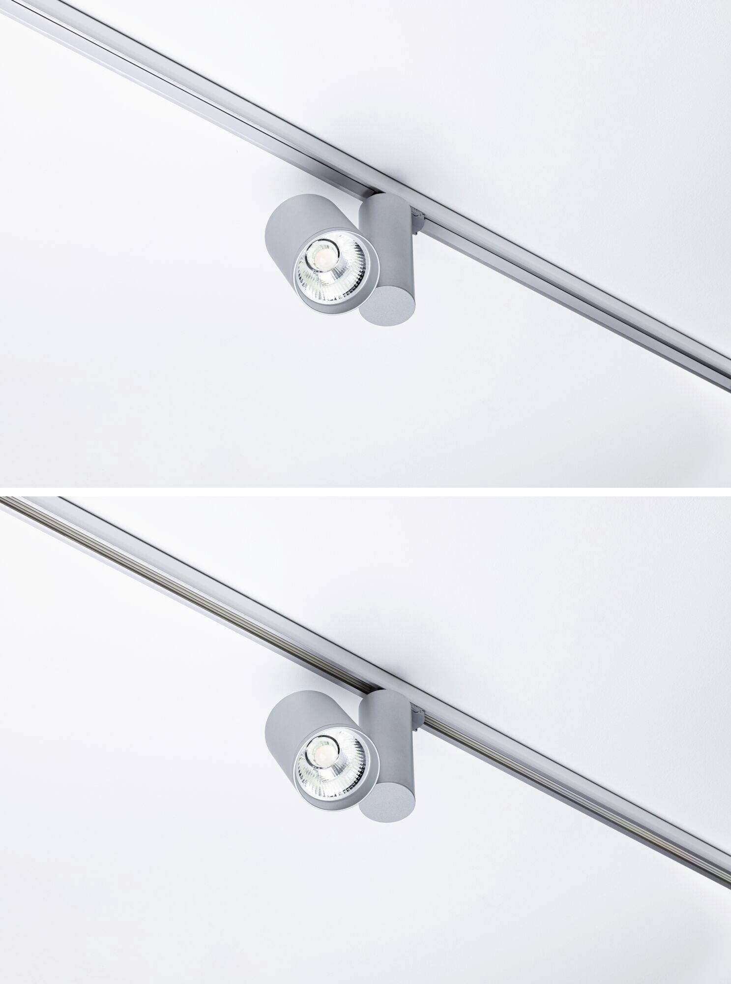 Dve okrúhle strieborné stropné svietidlá na lineárnej koľajnicovej sústave pred bielym pozadím, so svetlom smerujúcim nadol.