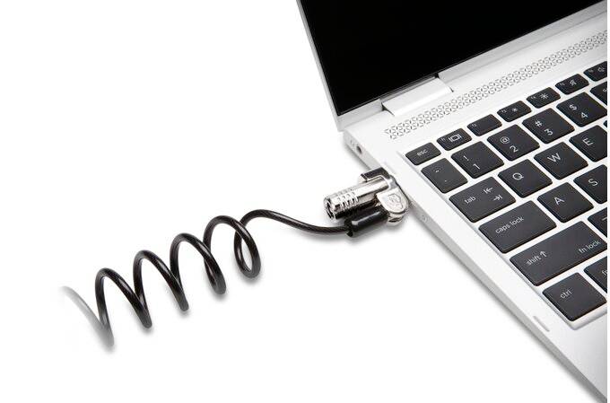 Laptop s pripojeným bezpečnostným káblom určeným na zabránenie krádeže. Kábel je navrhnutý v špirálovitom tvare.