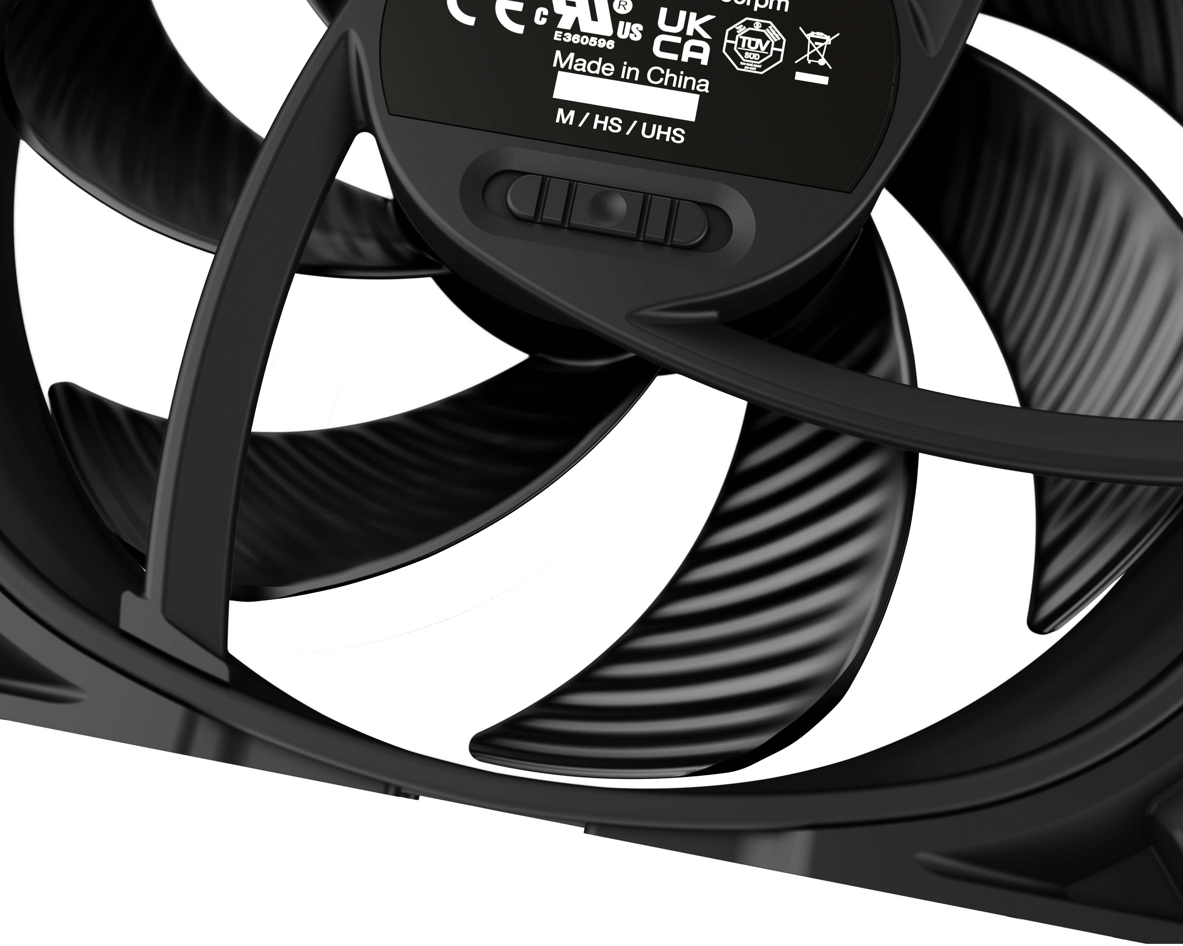 Čierny ventilátor s rotačnými lopatkami a centrálnou nálepkou, ktorá zobrazuje 'Made in China' a rýchlostné možnosti M, HS, UHS.