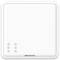 Štvorcový, biely vypínač so zaoblenými rohmi, namontovaný na bielej stene. V ľavom dolnom rohu sú tri malé priehlbiny.