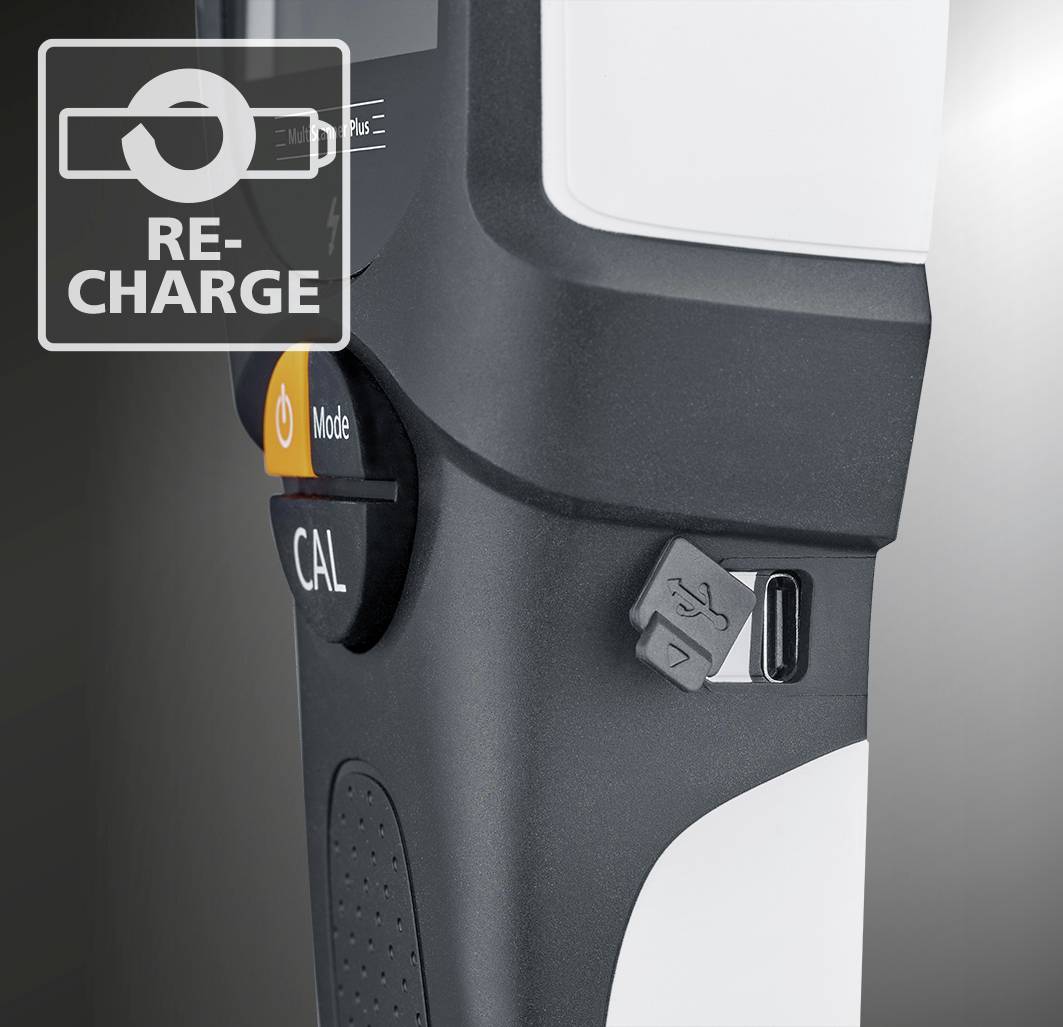 Detailný záber čierno-bieleho zariadenia s USB portom a oranžovým kalibračným tlačidlom označeným "RE-CHARGE"