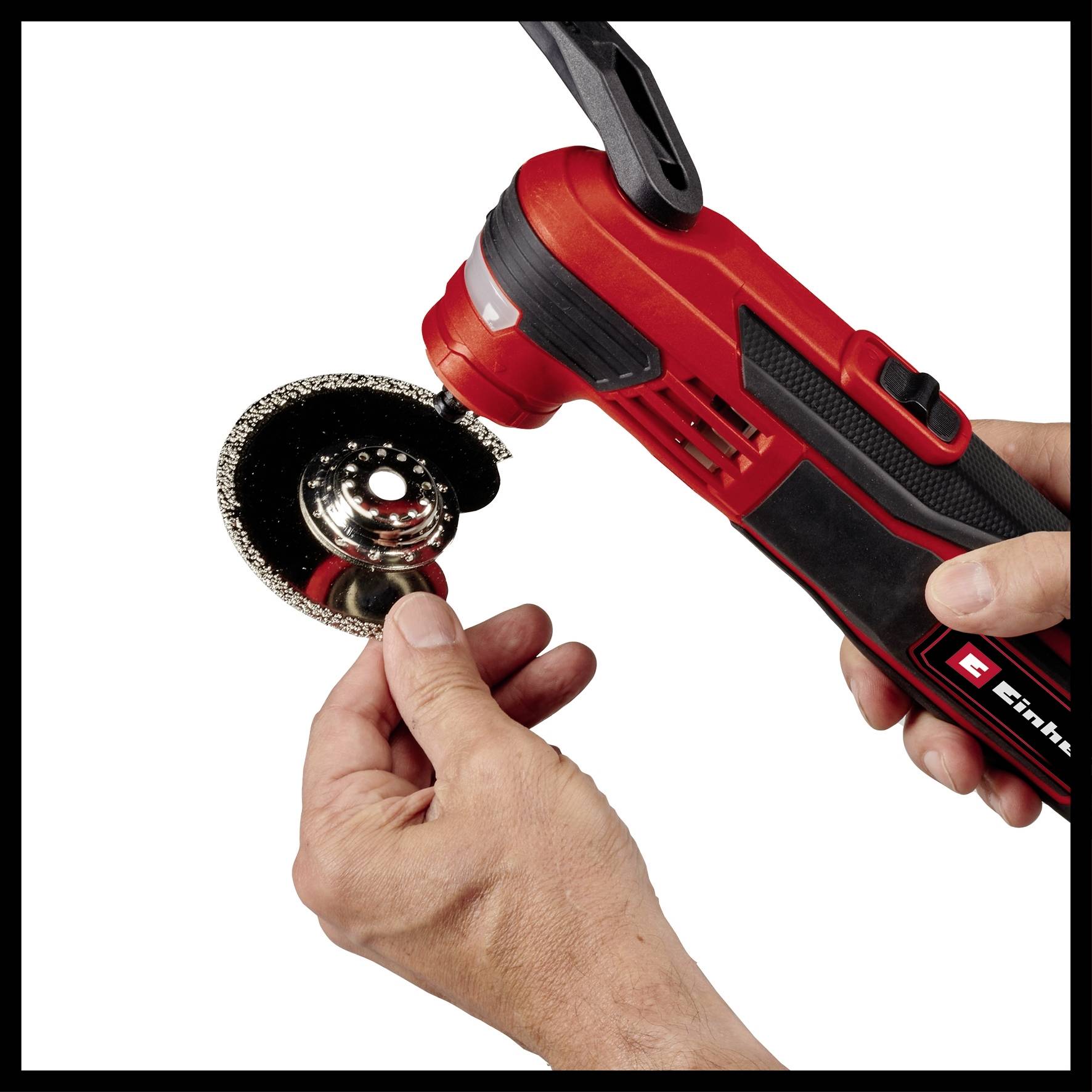 Osoba drží uhlovú brúsku v jednej ruke a druhou rukou nastavuje kotúč. Náradie v kontexte používania.