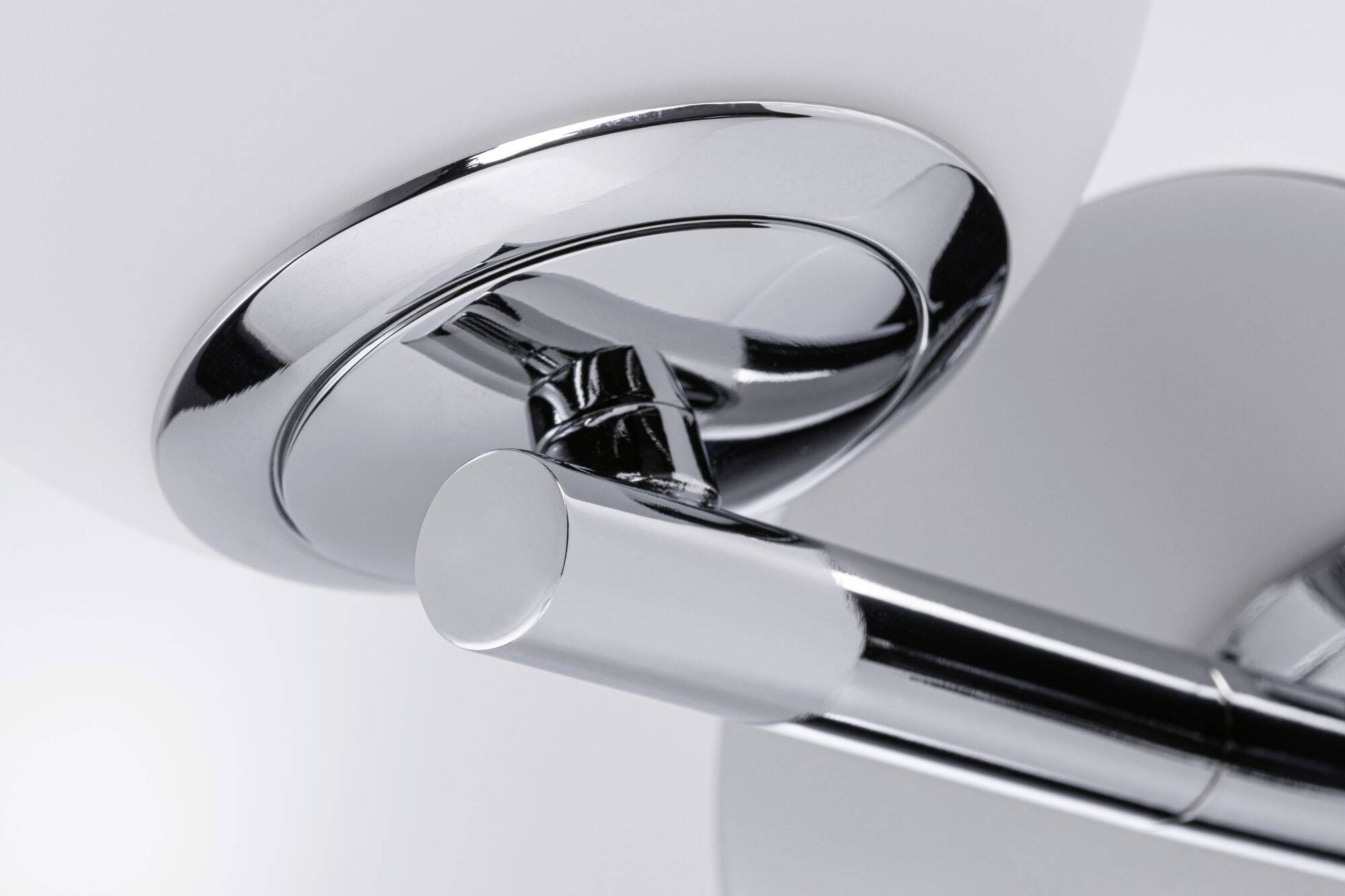 Detailný záber modernej, pochromovanej nástennej lampy s kruhovými prvkami, vhodnej do minimalistických alebo súčasných interiérov.