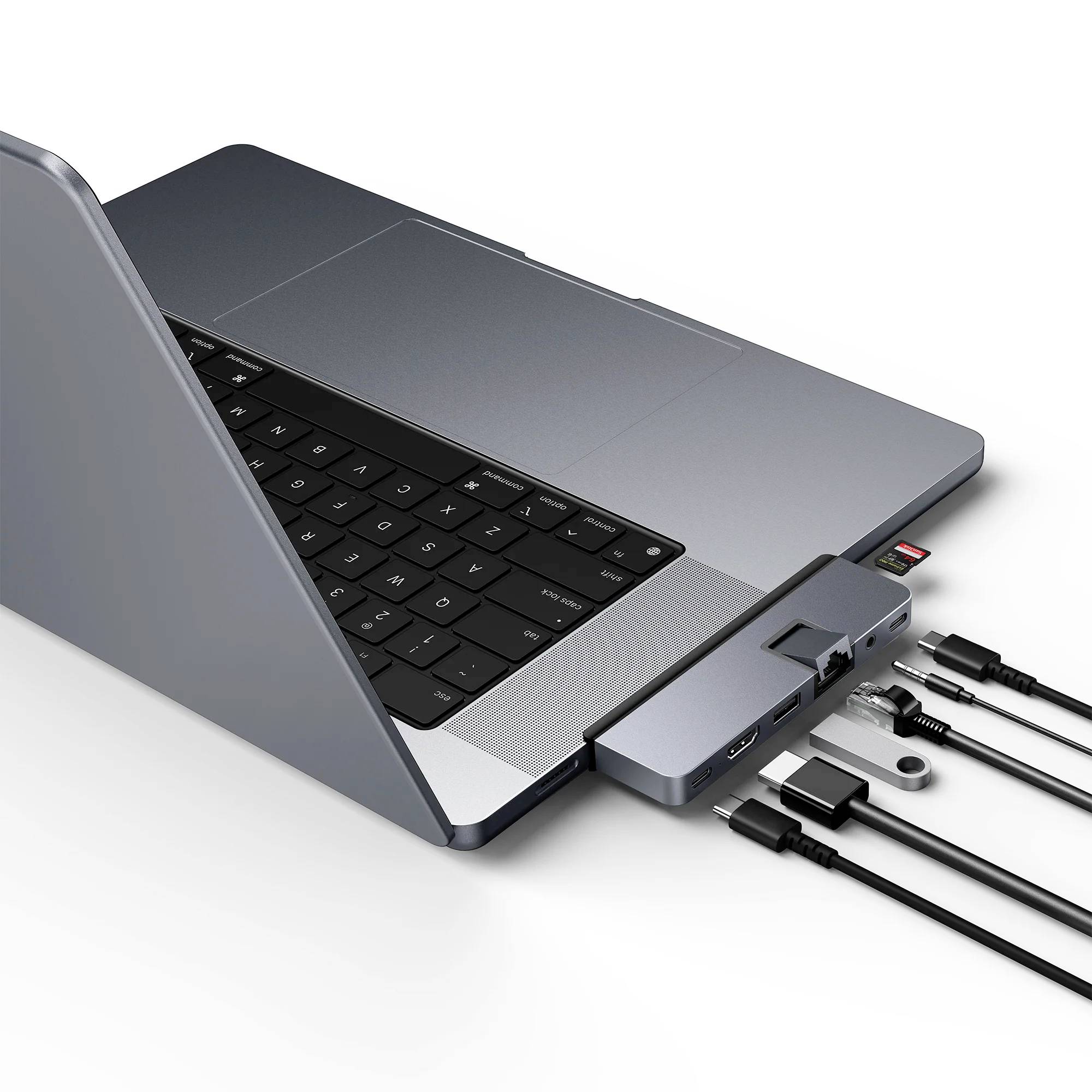 Laptop s pripojeným adaptérom, ktorý prepája rôzne káble ako USB, HDMI a čítačku SD kariet.