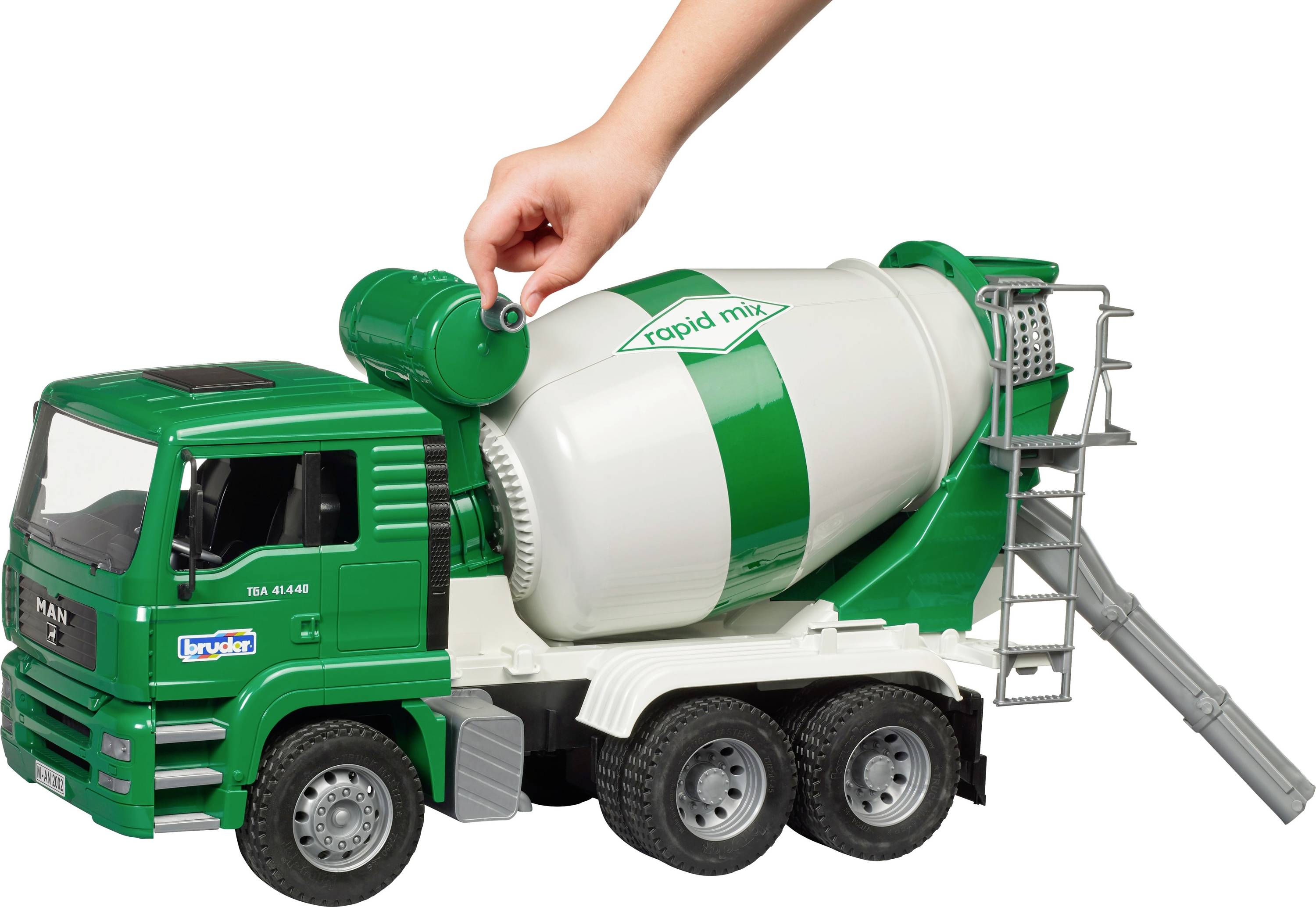 Dieťa napĺňa zelenú náplň do hračkárskeho betónového miešača. Nákladné auto je zeleno-biele s nápisom 'rapid mix'.