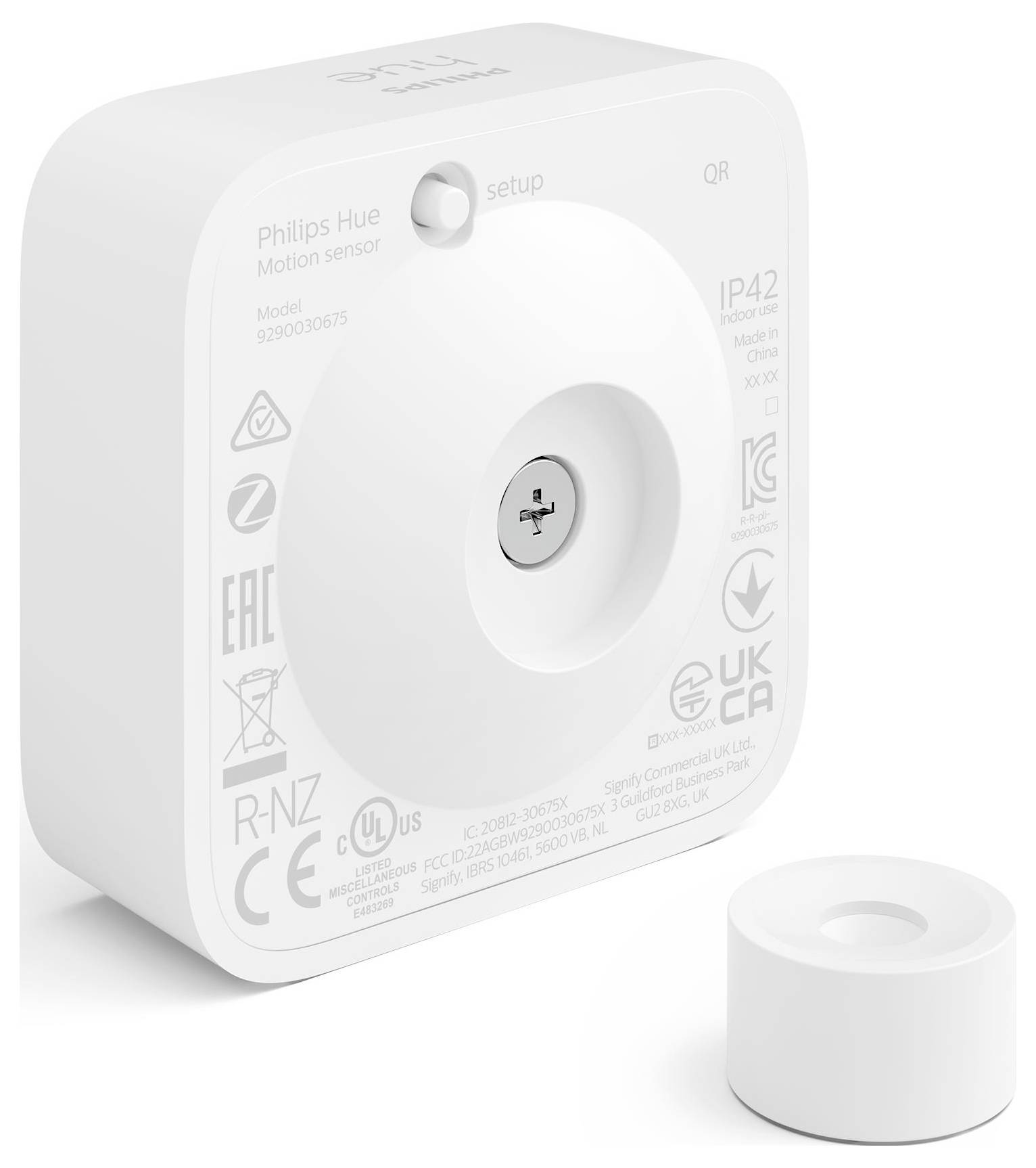 Biely snímač pohybu Philips Hue s QR kódom a nastavovacím tlačidlom. Obsahuje informácie o modeli a certifikačné značky na zadnej strane.