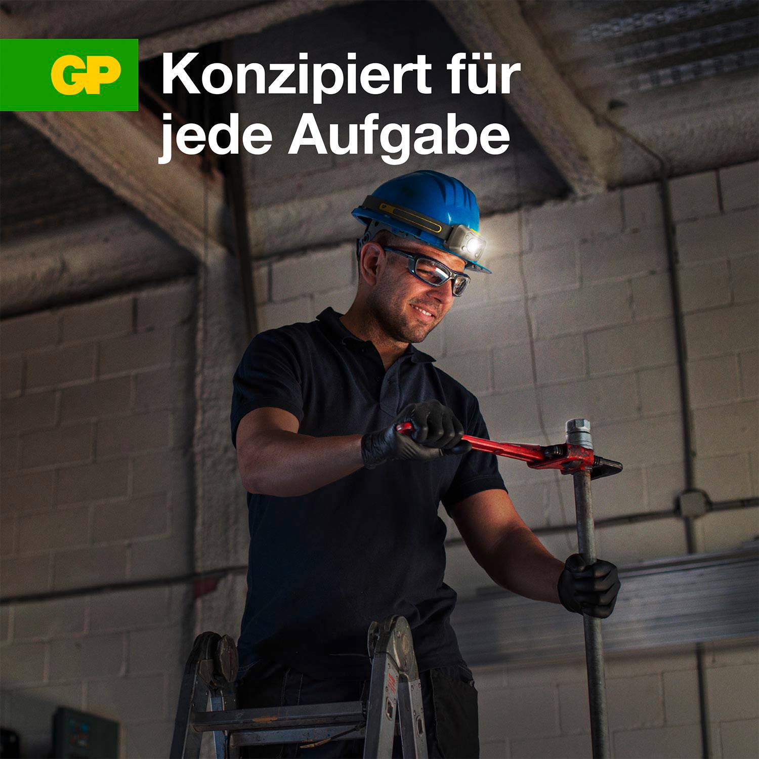 Remeselník na rebríku pracuje s inštalatérskym kľúčom. Text: 'NAVRHNUTÉ PRE KAŽDÚ ÚLOHU'. Pozadie: priemyselná budova.