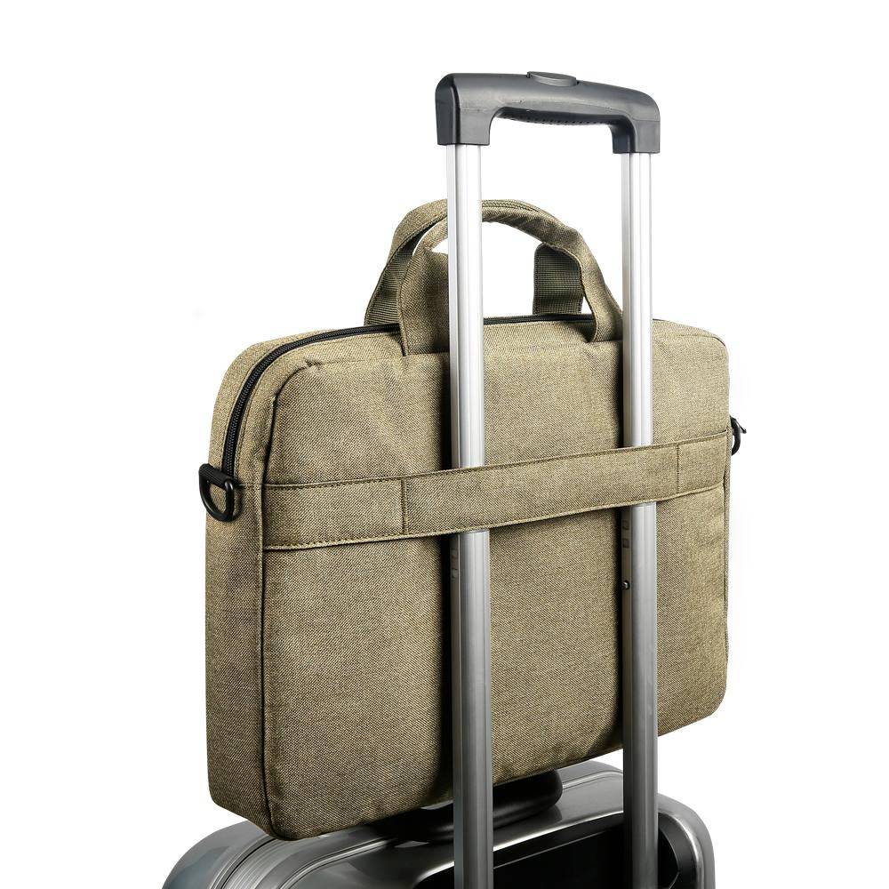 Béžová taška s rukoväťou je prevesená cez rukoväť strieborného cestovného kufra.