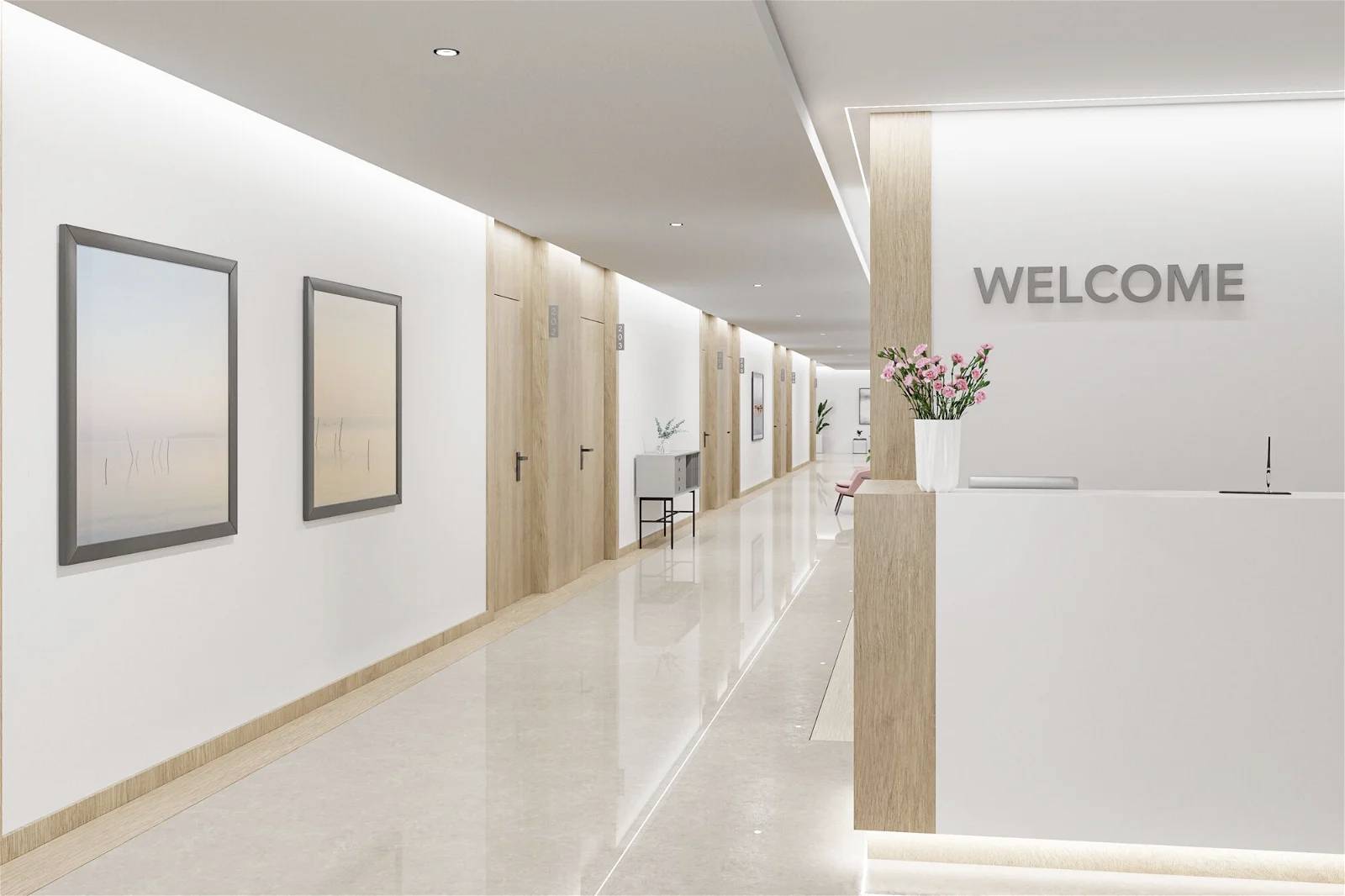 Svetlý, moderný recepčný priestor s nápisom 'WELCOME', bielymi stenami, drevenými detailmi, kvetinovými vázami a dvoma zarámovanými obrázkami na stene.