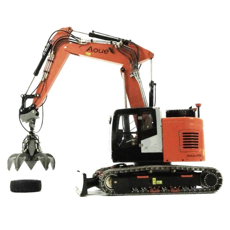 Oranžový mobilný žeriav s uchopovacím ramenom drží pneumatiku. Žeriav sa pohybuje pomocou pásového podvozku.