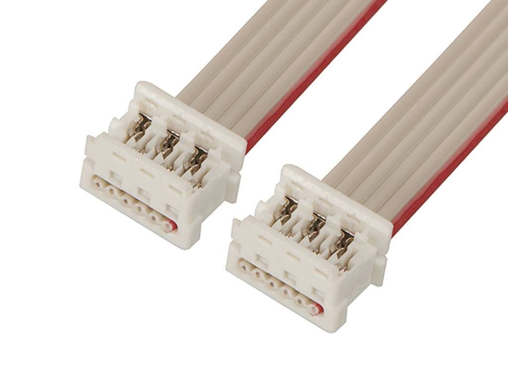Dva biele plastové konektory s viacerými kovovými kontaktmi sú prepojené sivým plochým pásovým káblom. Slúžia na elektrické prepojenie.