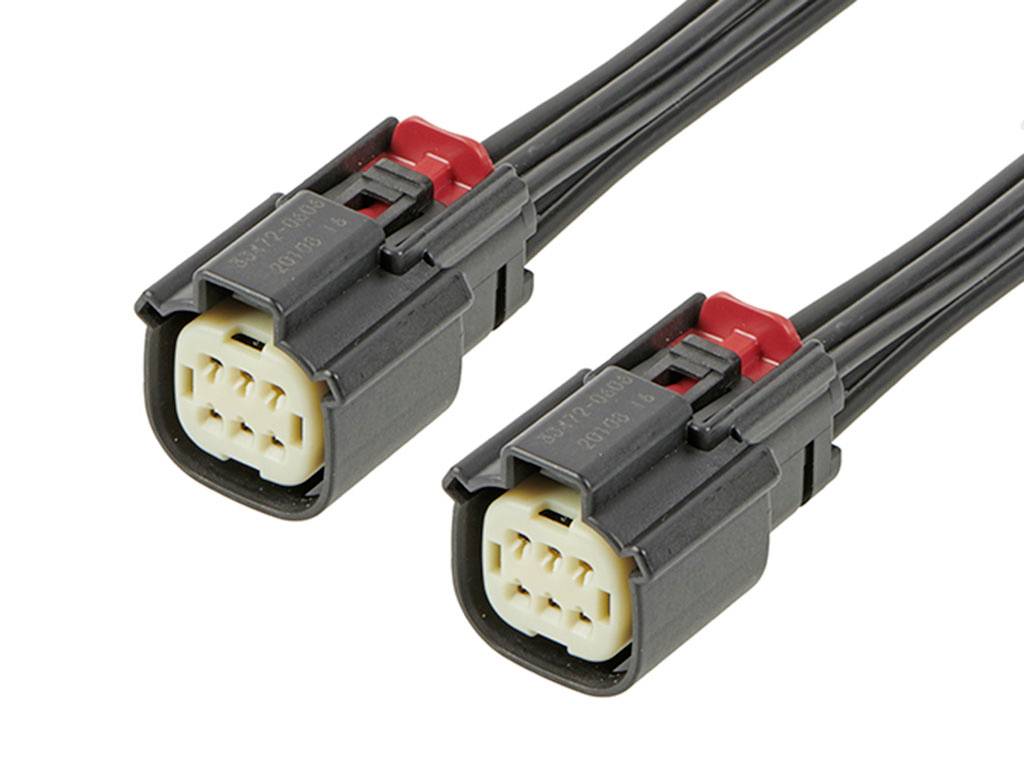 Dva čierne elektrické konektory s červenými svorkami a šiestimi kolíkmi, položené vedľa seba, ukazujú možnosti pripojenia.