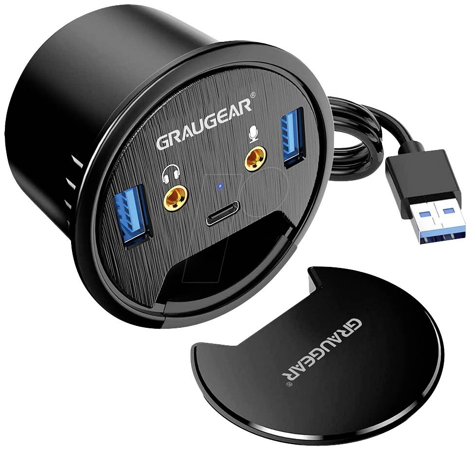 Okrúhle pole prípojok so značkovým názvom, dvomi USB portami, HDMI a audio konektormi, vedľa s odnímateľným krytom.