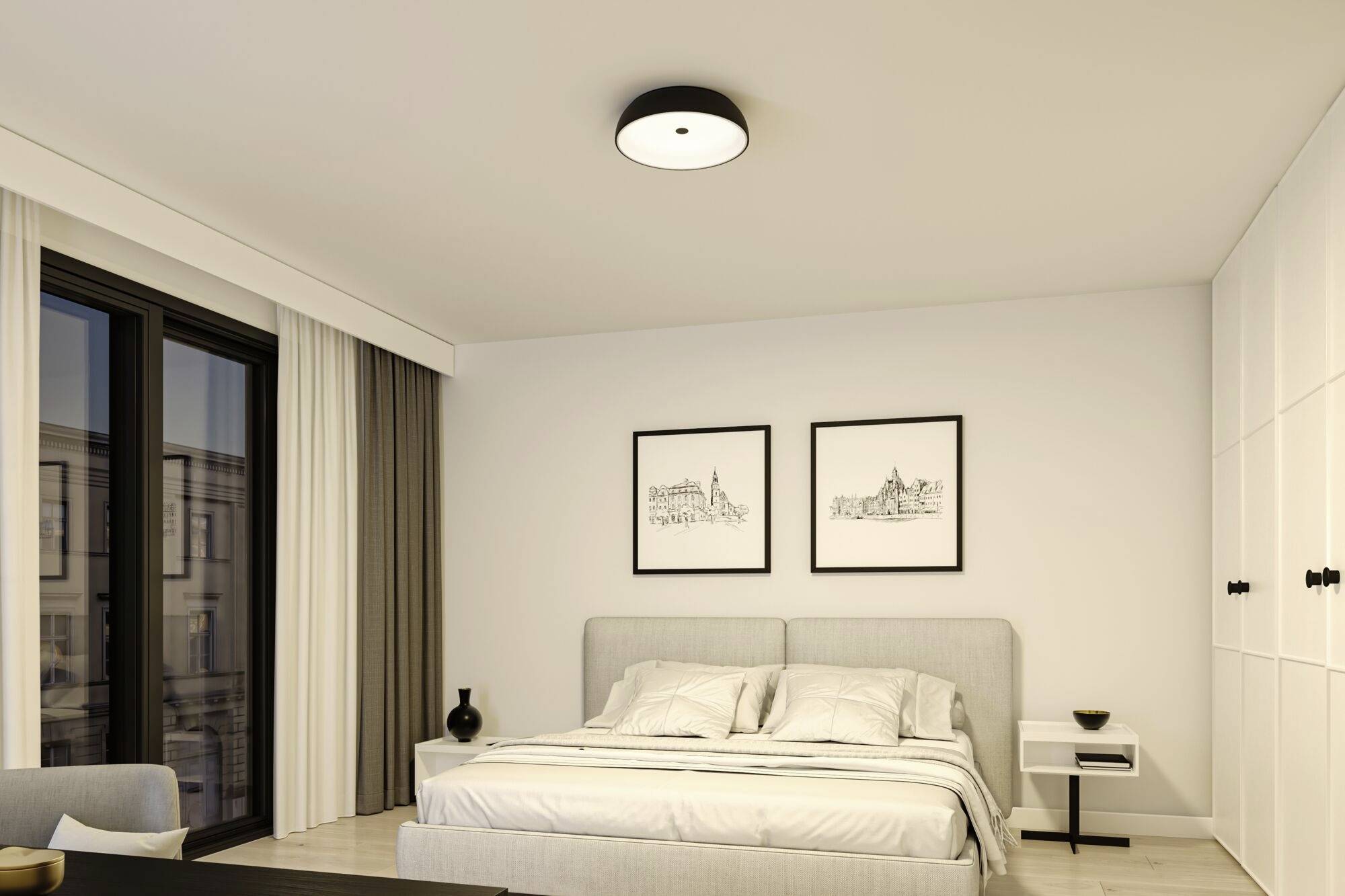 Moderná spálňa s veľkou posteľou, dvoma obrazmi na stene, oknom so záclonami a nočným stolíkom s lampou.