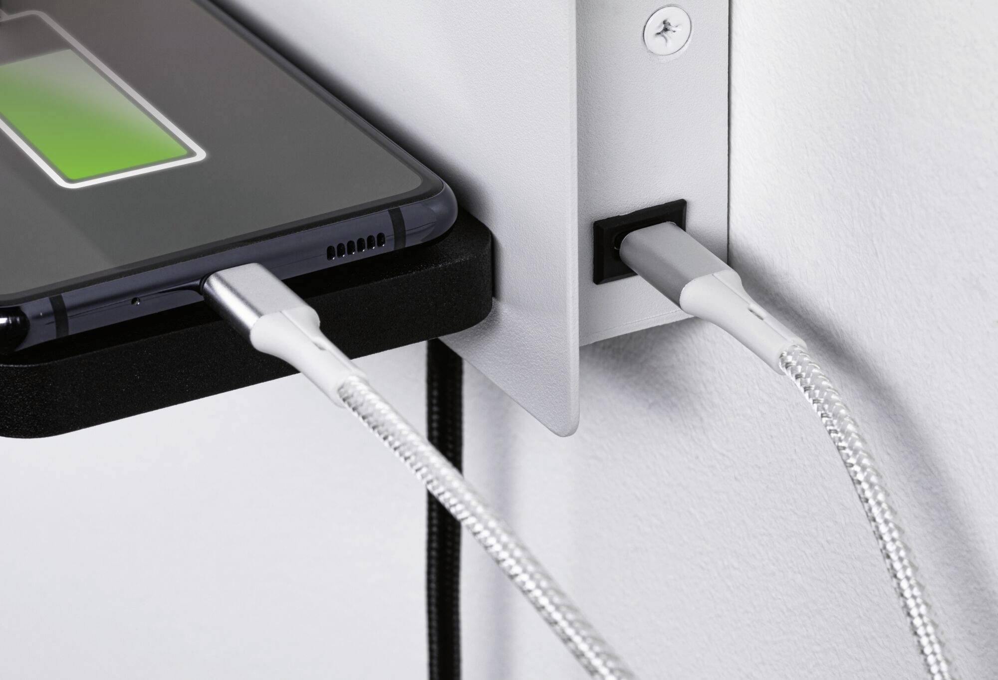 Smartfón na nabíjačke so zeleným symbolom batérie; dva káble pripojené.