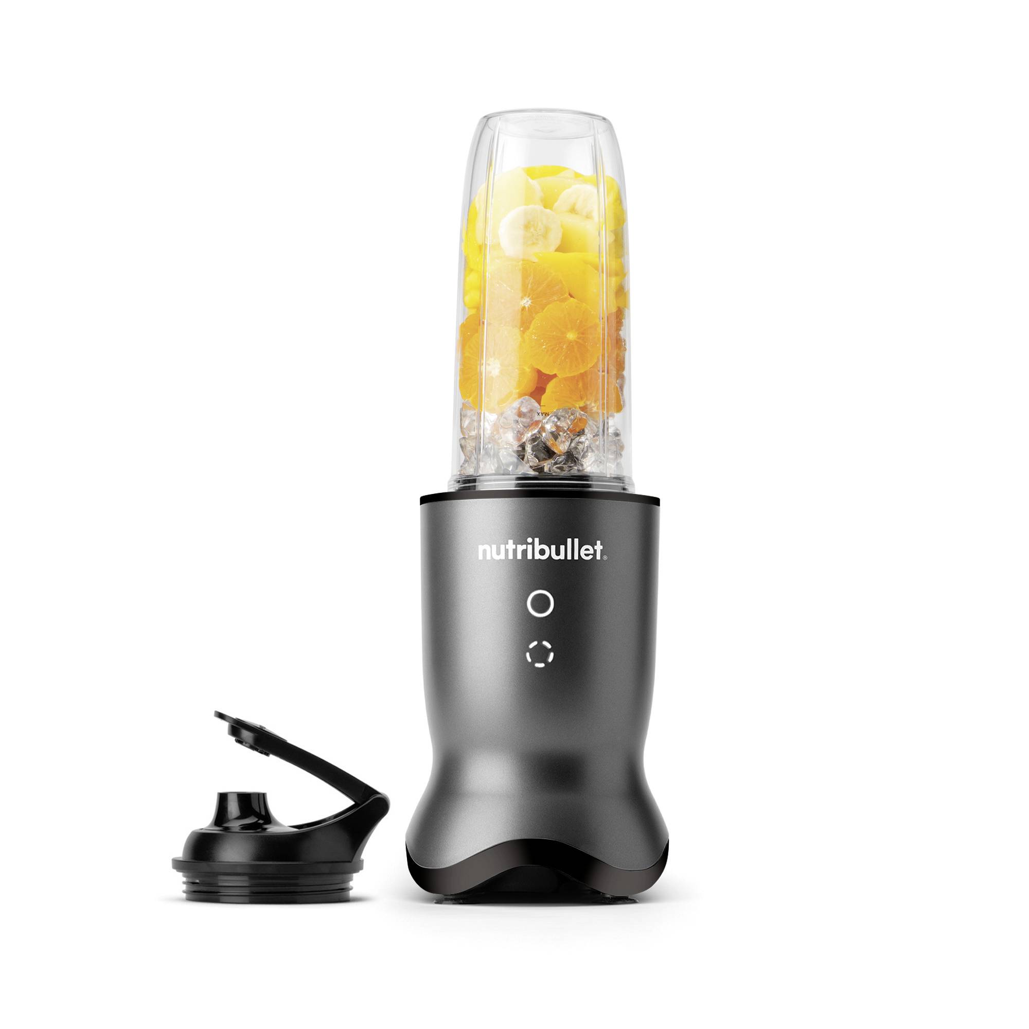 Čierny mixér značky 'nutribullet' so snímateľným vekom, naplnený pomarančmi, banánmi a kockami ľadu, stojí vzpriamene.