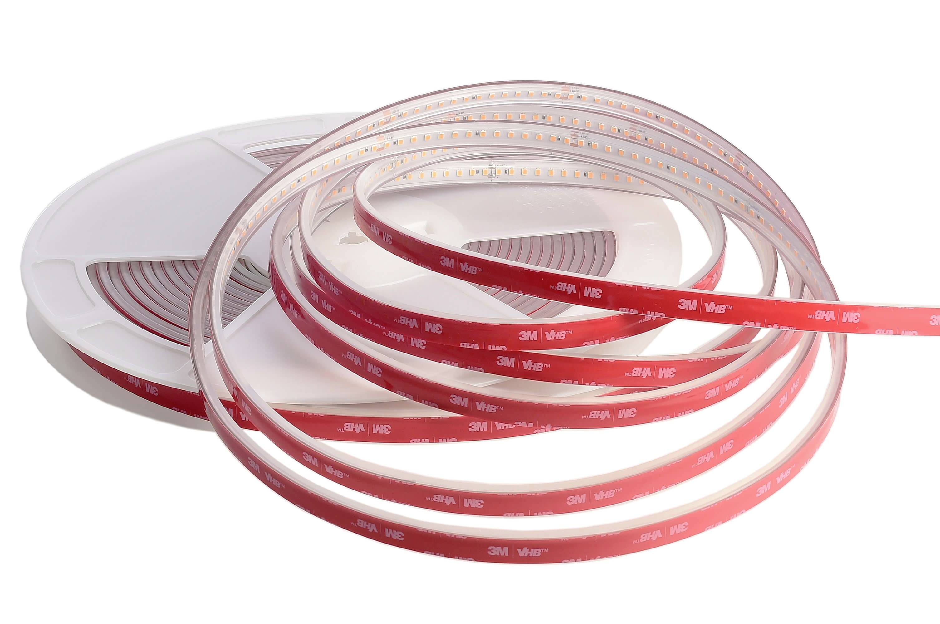 Navinutý červeno-biely LED pásik na cievke, pripravený na inštaláciu. Je samolepiaci a flexibilný.