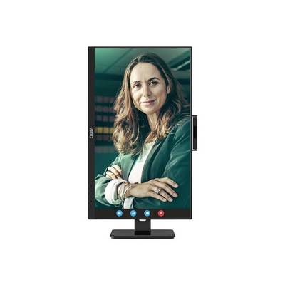 Osoba s kučeravými vlasmi sa usmieva do kamery, stojac pred rozmazaným pozadím v prostredí videohovoru.