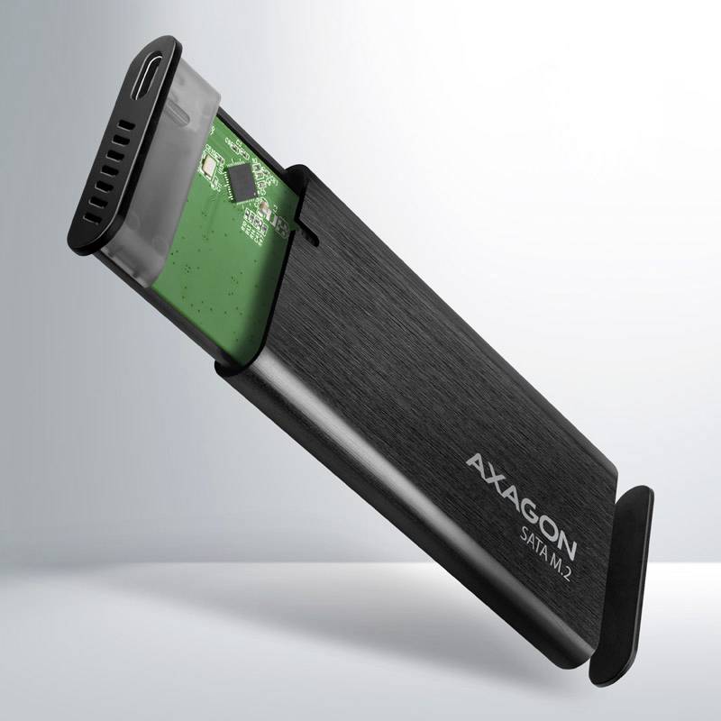 Externý SSD box v čiernej farbe s otvoreným posuvným mechanizmom, ktorý odhaľuje zelenú dosku plošných spojov. Značka 'AXAGON SATM.2'.