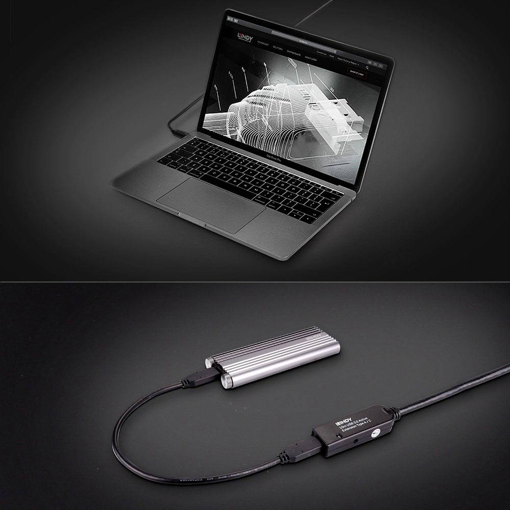 Laptop zobrazuje 3D dizajn na obrazovke. Pod ním je elektronické zariadenie pripojené káblom.