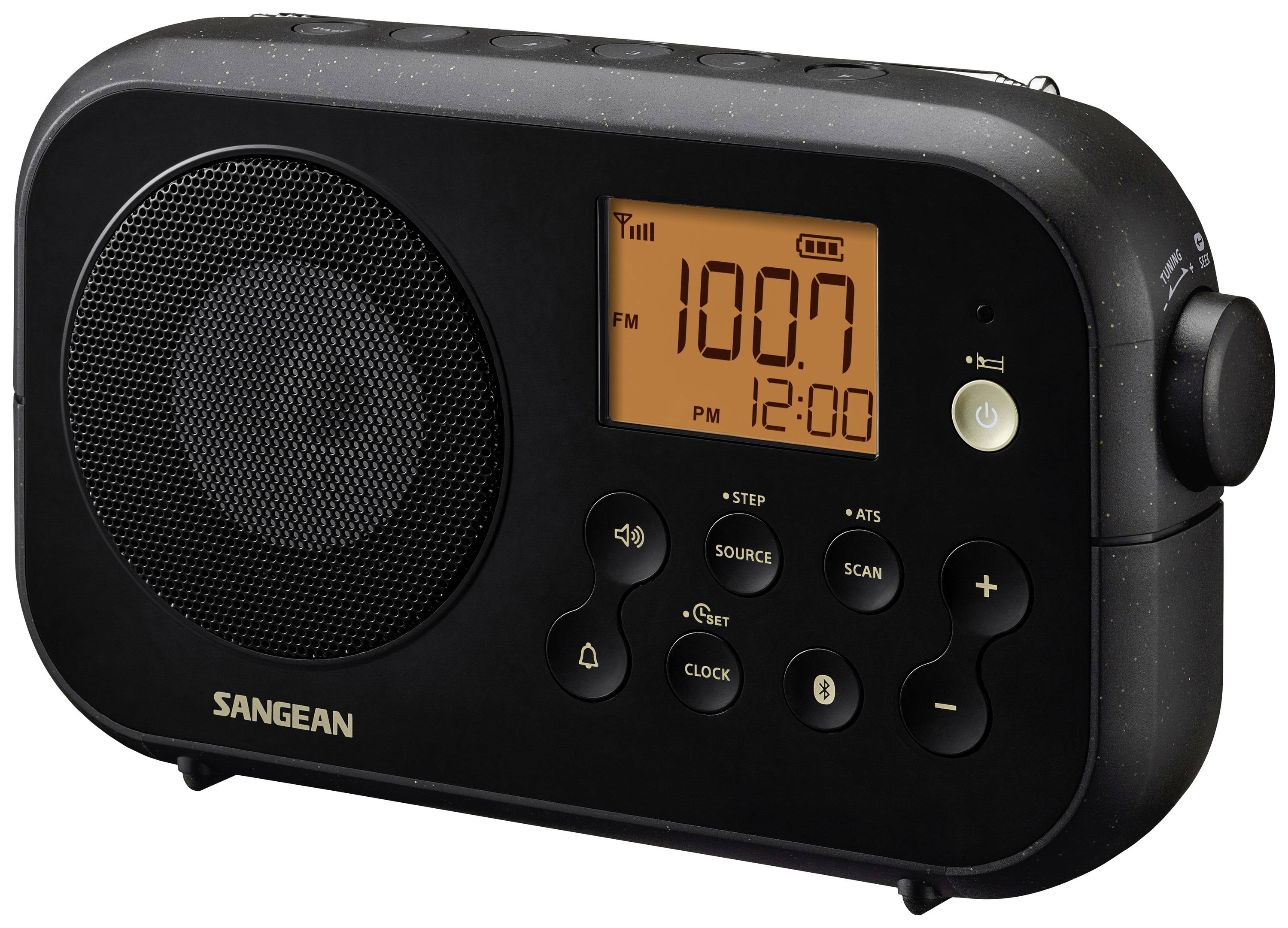Čierne prenosné rádio s podsvietením displeja, na ktorom svieti '100.7 FM' a '12:00'. Na prednej strane sú ovládacie tlačidlá na nastavenia a hlasitosť.
