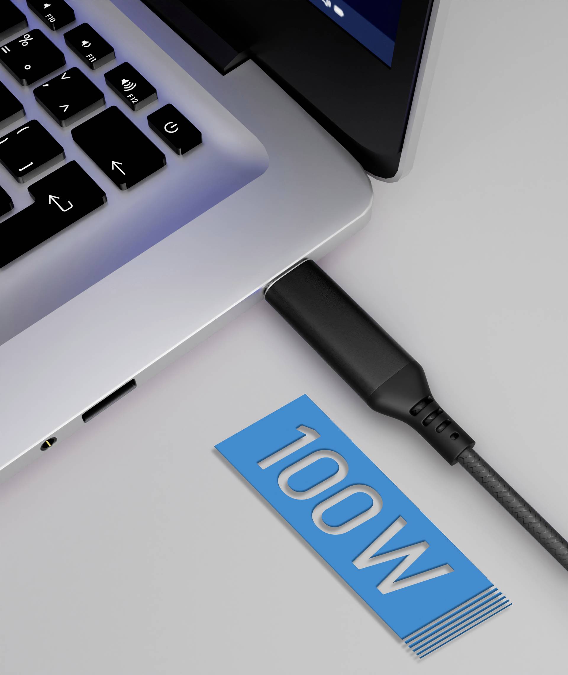 Notebook s pripojeným nabíjacím káblom, vedľa ktorého leží modrá karta s nápisom '100W', čo poukazuje na nabíjací výkon.