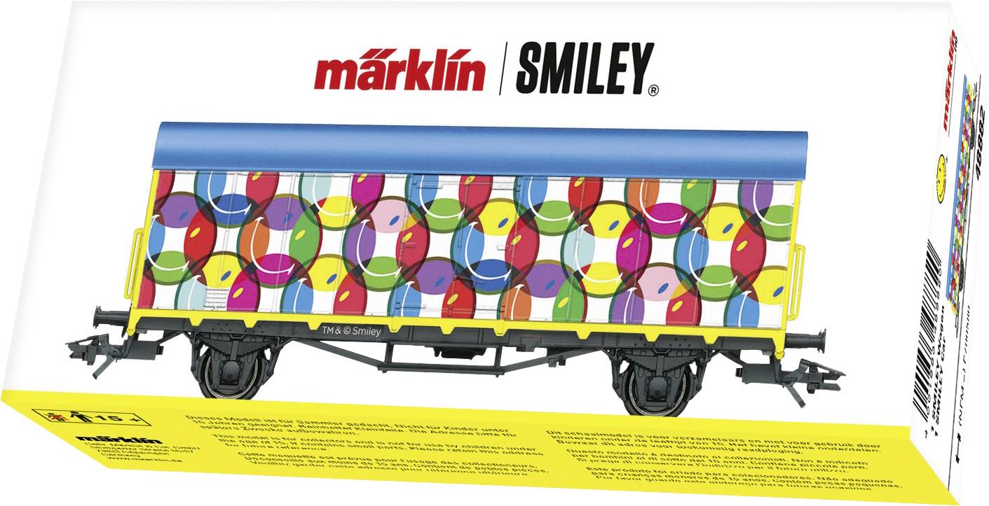 Farebný modelový nákladný vagón s veselými smajlíkmi a modrou strechou v balení s nápisom 'märklin SMILEY'.