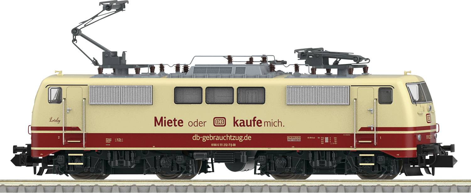 Žltá a červená lokomotíva s nápisom 'Prenajmi alebo ma kúp. db-gebrauchtzug.de'. Stojí na železničných koľajach.