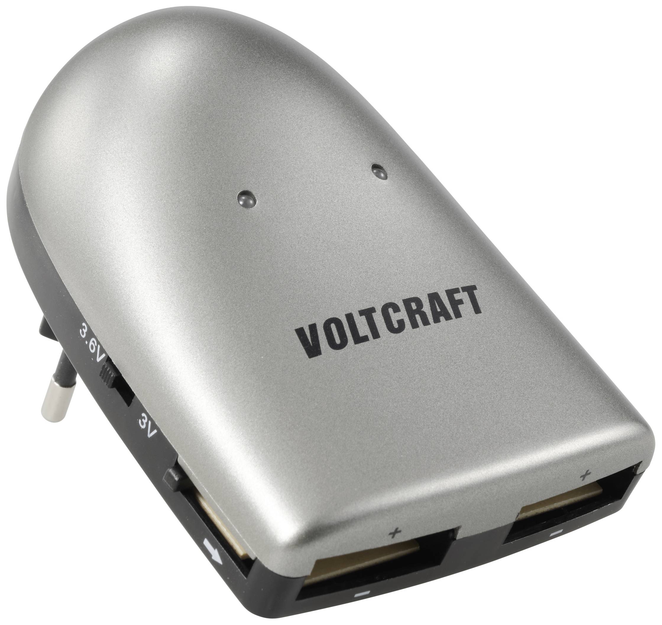 Na obrázku je strieborná nabíjačka značky Voltcraft s pripojením do elektrickej zásuvky a dvoma USB výstupmi na napájanie zariadení.