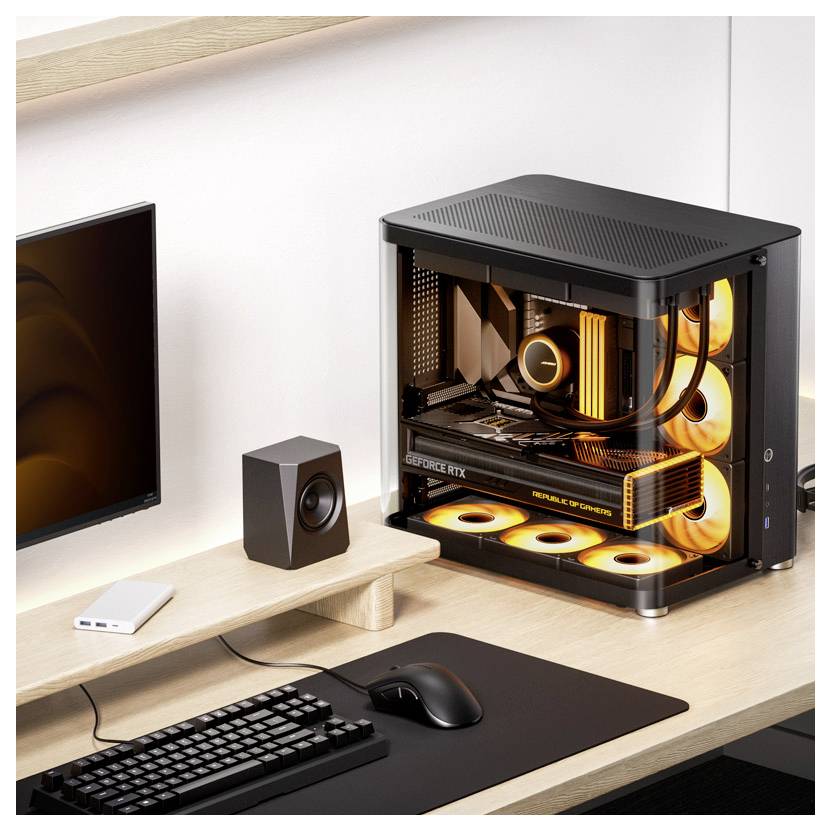 Písací stôl s počítačovou zostavou a monitorom. Počítač má nápadný, žltým svetlom osvetlený vnútorný priestor. Klávesnica a myš sú tiež viditeľné.