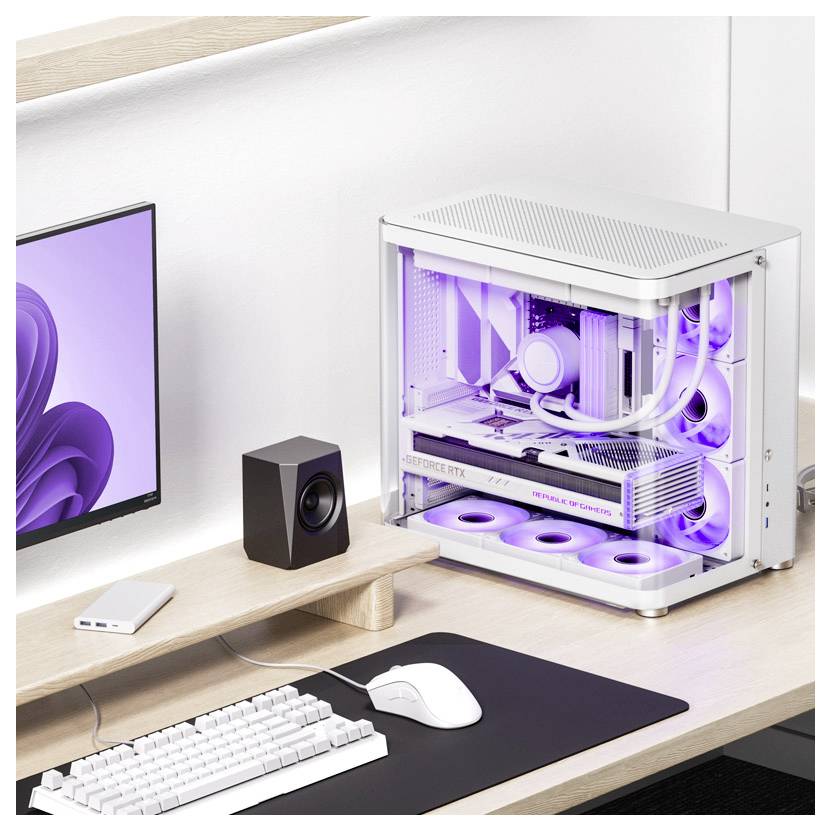 Moderné počítačové pracovisko s fialovo podsvietením PC krytom, monitorom, reproduktormi, myšou a klávesnicou na stole.